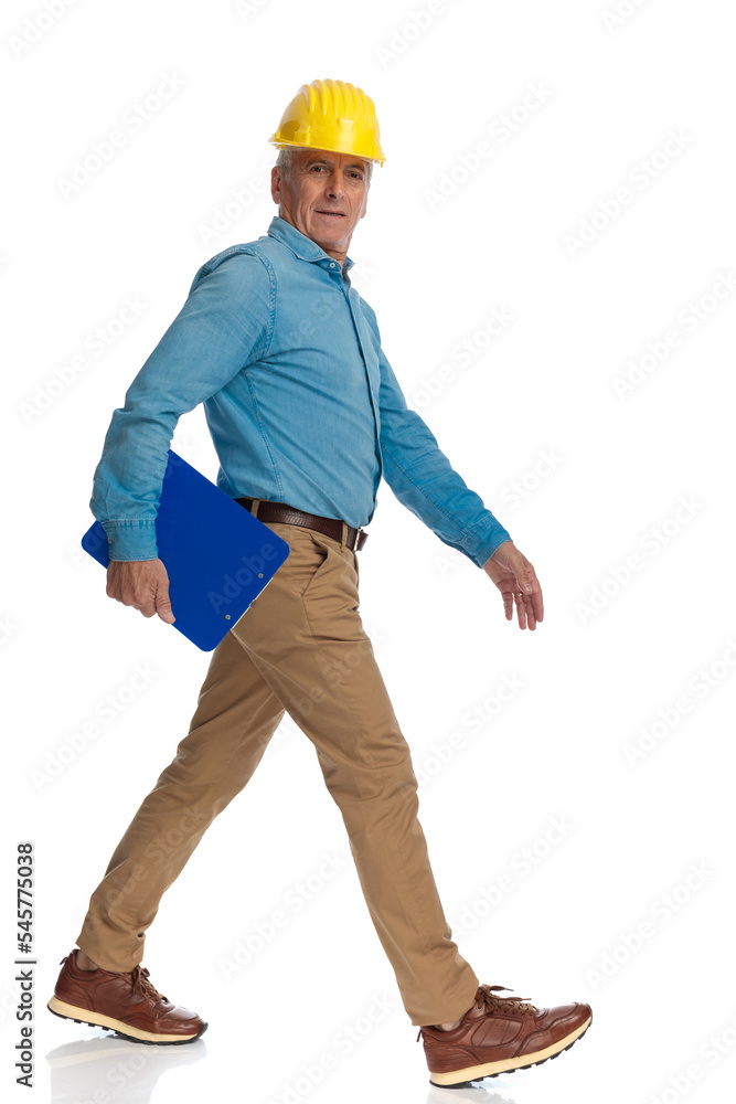 serious old man in his 60s walking to check the construction serious old man in his 60s walking to check the construction