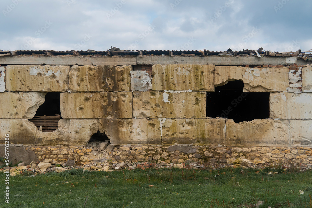 Wall with holes after shelling. War in Ukraine. Russian invasion of Ukraine. Destruction of infrastructure. Terror of the civilian population. War crimes