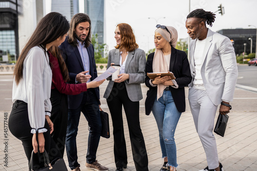Group of young multiracial entrepreneurs discussing new proposals in the open air outside the office. Group of entrepreneurs. Businesswomen and businessmen