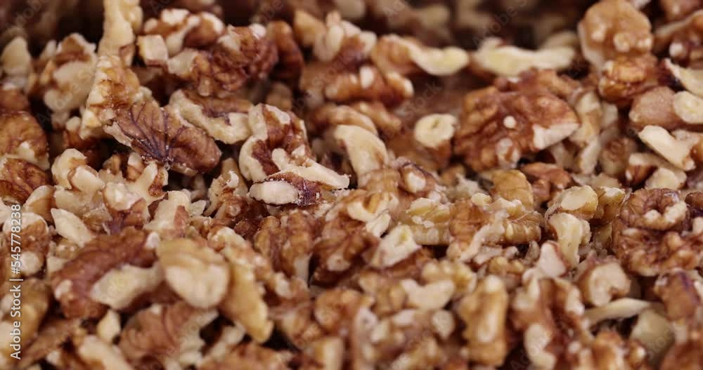 Cut walnuts on a board, cut ripe walnuts into pieces for use in confectionery Cut walnuts on a board, cut ripe walnuts into pieces for use in confectionery