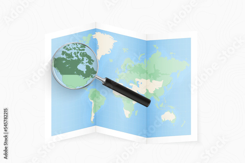 Enlarge Canada with a magnifying glass on a folded map of the world.