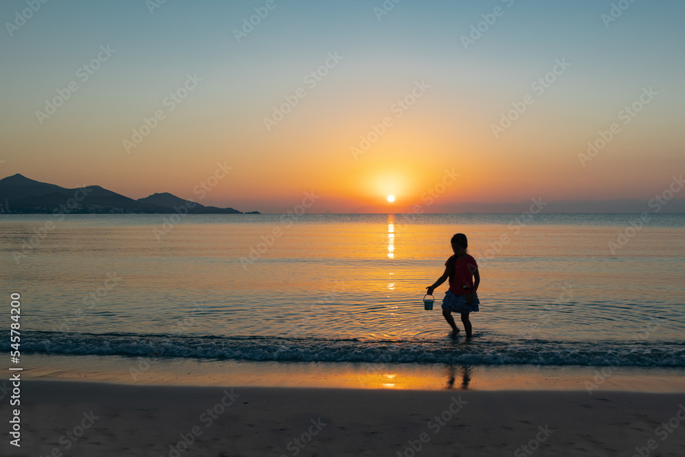 child playing on the beach at sunrise