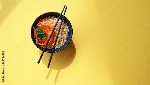 vegetarian ramen noodles with chopsticks pattern on yellow background 