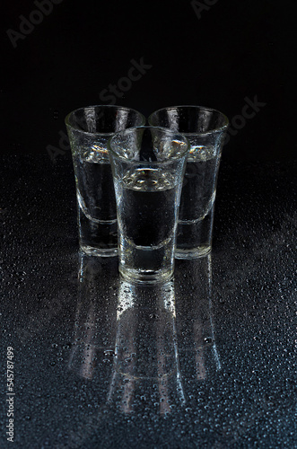 reflection of glass stacks on a black background, stacked in a pyramid on a mirror surface