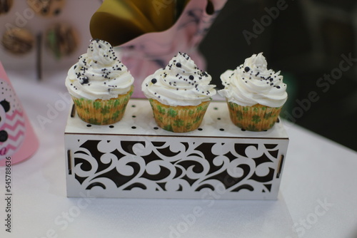 Black and white cakes on the buffet stand in front of the decoration decorated with filling