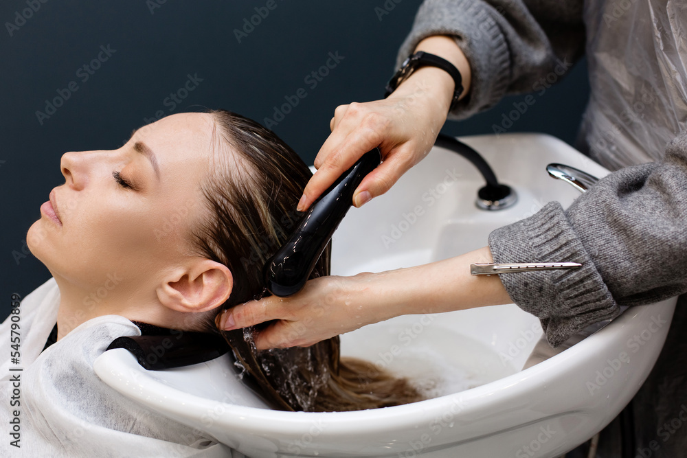 Woman with hairdresser washing head at hair salon Woman with hairdresser washing head at hair salon
