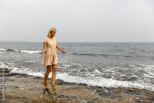 Stylish young woman walking by the sea, the concept of a healthy lifestyle