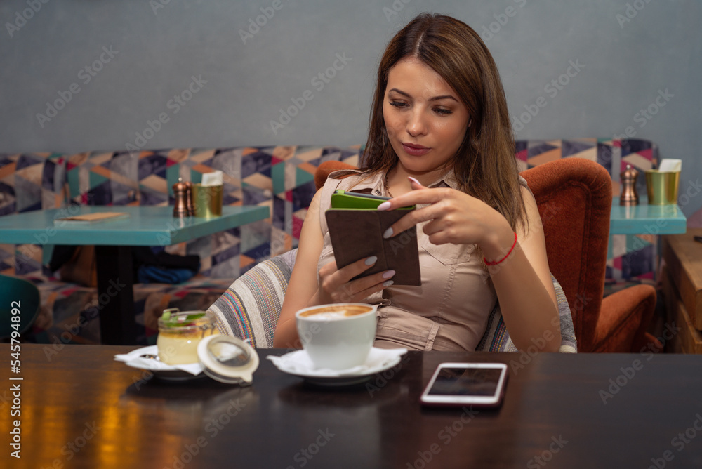 Beautiful woman using a mobile phone in cafe. Reading e-book Beautiful woman using a mobile phone in cafe. Reading e-book