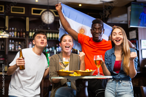 Joyful fans of the Argentina team celebrating the victory in the night bar