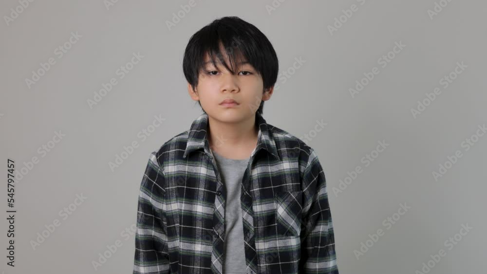 Asian boy stands still and stares the camera. Anger, Unsatisfied, Rebellious. 25P Asian boy stands still and stares the camera. Anger, Unsatisfied, Rebellious. 25P