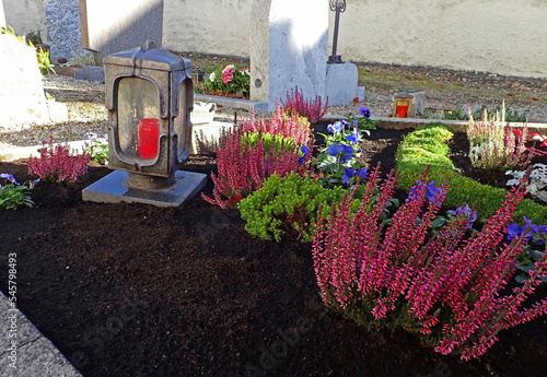 Schön geschmückte Gräber auf einem Friedhof an Allerheiligen im Herbst

 photo