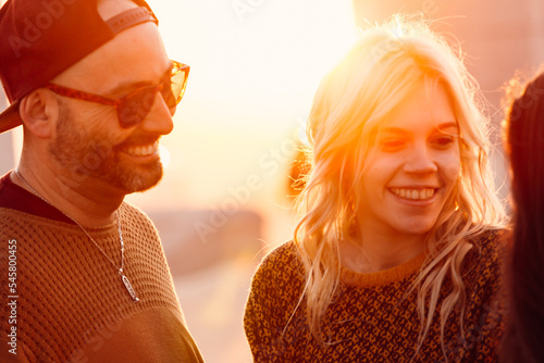 People in love smiling outdoors with sunset backlight