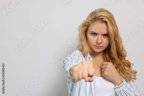 Wallpaper Mural Young woman ready to fight on white background. Space for text Torontodigital.ca