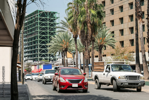 Beautiful view of city street with modern buildings and palm trees © New Africa