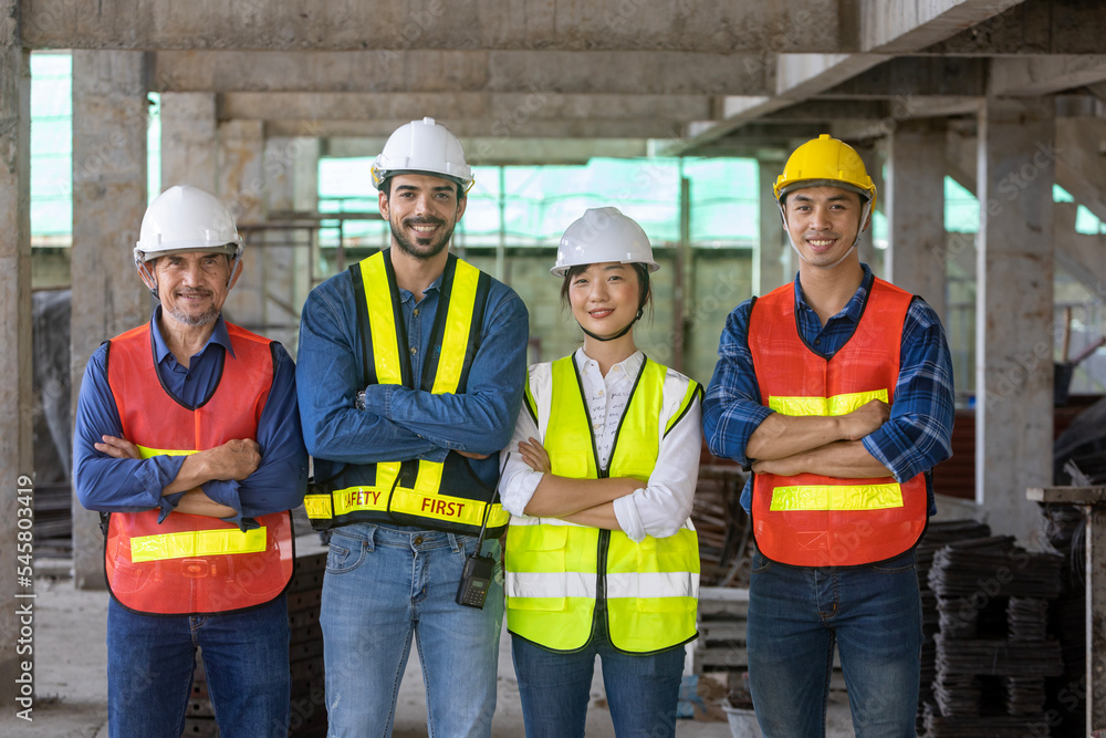 Portrait of experienced diversity team of engineer, architect, worker and safety manager smiling together at the construction site in safety vest and helmet Portrait of experienced diversity team of engineer, architect, worker and safety manager smiling together at the construction site in safety vest and helmet