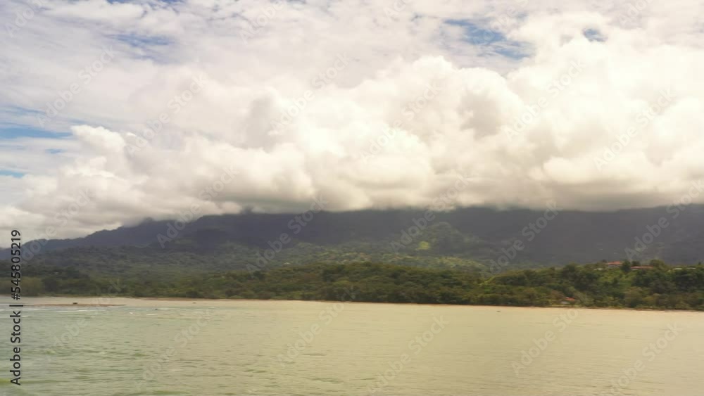 Drone pans across the sea with an estuary. In the background you can see the mountains and clouds 4K Video Copy Space Drone pans across the sea with an estuary. In the background you can see the mountains and clouds 4K Video Copy Space