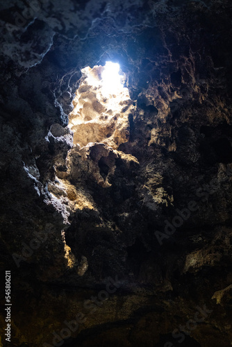 sun light coming through an opening in the roof of a cave