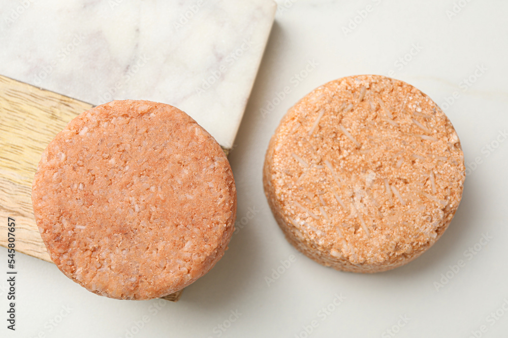 Natural solid shampoo bars on light table, flat lay Natural solid shampoo bars on light table, flat lay