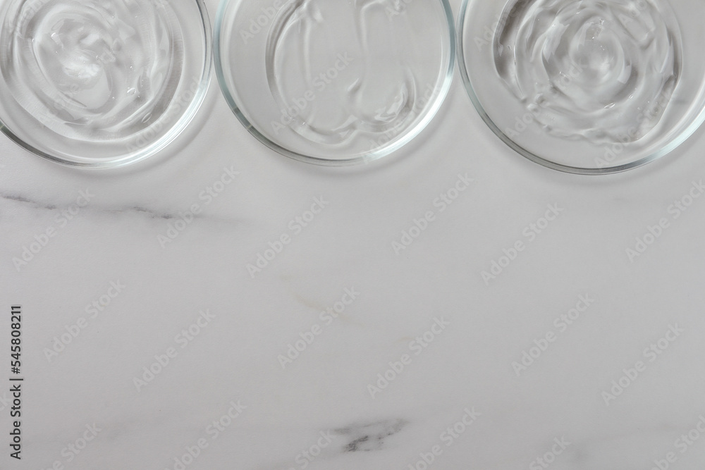 Petri dishes with liquids on white marble table, flat lay. Space for text Petri dishes with liquids on white marble table, flat lay. Space for text