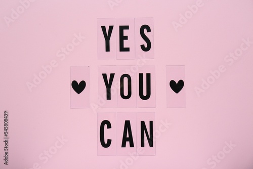 Fotografie Phrase Yes You Can and hearts on pink background, top view