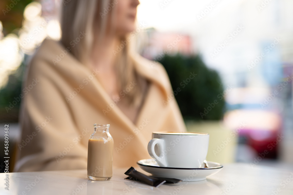 a fragrant and warm mug of cappuccino with a drawing heart, girl hold in hands. a fragrant and warm mug of cappuccino with a drawing heart, girl hold in hands.