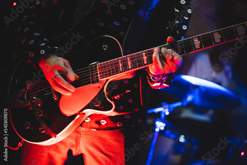 close up play electric guitar at a rock concert.