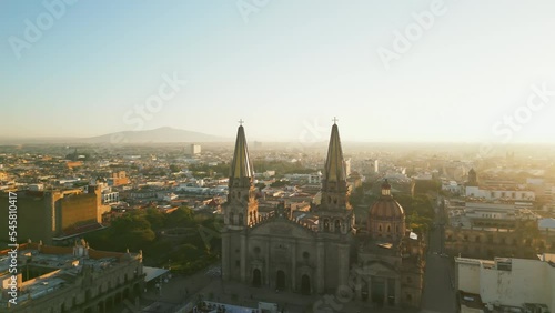 Beautiful golden hour lighting above the Cathedral with gothic spires. Aerial, panoramic view of historical Colonial architecture of Guadalajara, Mexico. High quality 4k footage photo