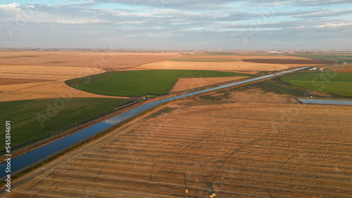 Drone view during sunrise over a farm hay field and river in Alberta Canada
