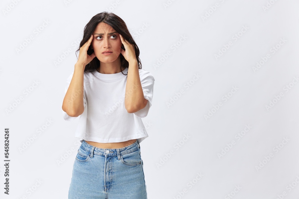 Woman headache and sadness, stress and depression, woman in a white t-shirt on a white background illness, copy space Woman headache and sadness, stress and depression, woman in a white t-shirt on a white background illness, copy space