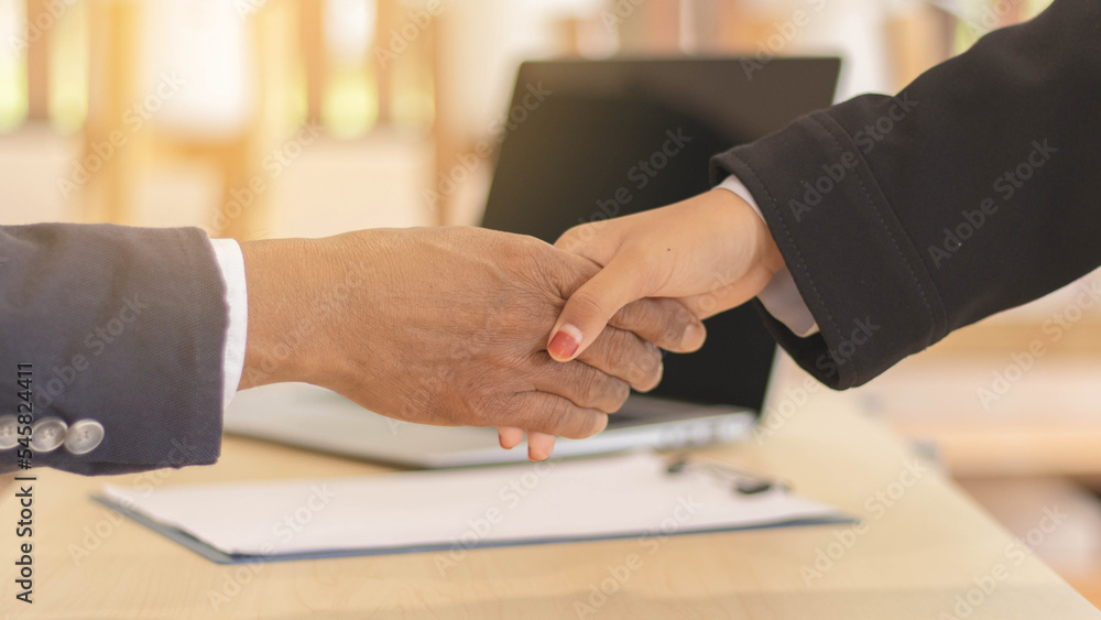 Close-up business men holding hands, Two businessmen are agreeing on business together and shaking hands after a successful negotiation.