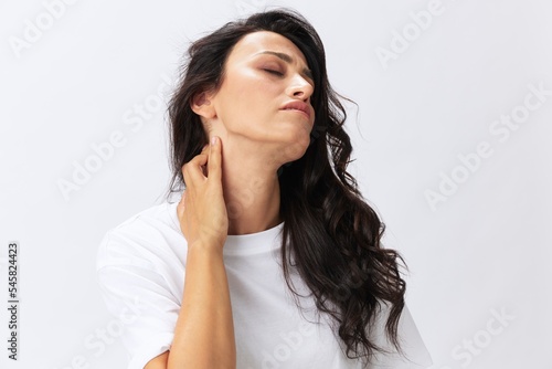 Woman sadness pain in the neck, back and head, spasms and diseases at a young age, white background, copy space © SHOTPRIME STUDIO