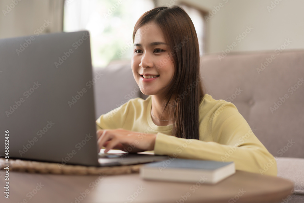 Leisure activity concept, Young woman typing on laptop while sitting to relaxation on the floor Leisure activity concept, Young woman typing on laptop while sitting to relaxation on the floor