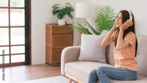 Concept of activity in home, Young woman in headphone listen music and sing while sitting on couch