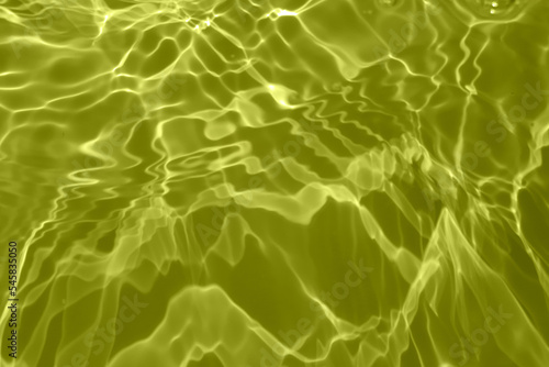 Defocus blurred transparent soft yellow colored clear calm water surface texture with splashes and bubbles. Trendy abstract nature background. Water waves in sunlight with copy space. Soft water shine