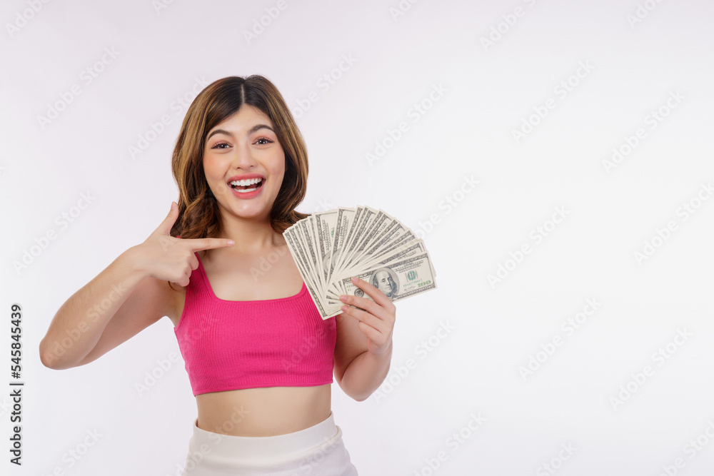 Portrait of excited young woman holding bunch of dollars banknotes and pointing finger at money isolated over white background Portrait of excited young woman holding bunch of dollars banknotes and pointing finger at money isolated over white background