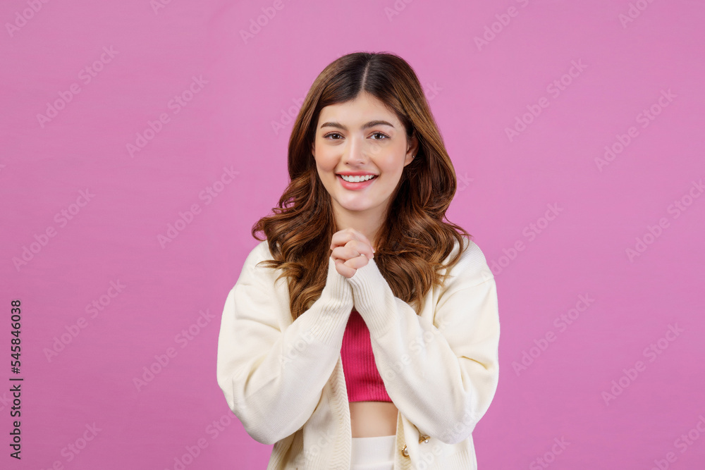 Portrait of Smiling young woman praying with folded hand or making a wish isolated over pink background Portrait of Smiling young woman praying with folded hand or making a wish isolated over pink background