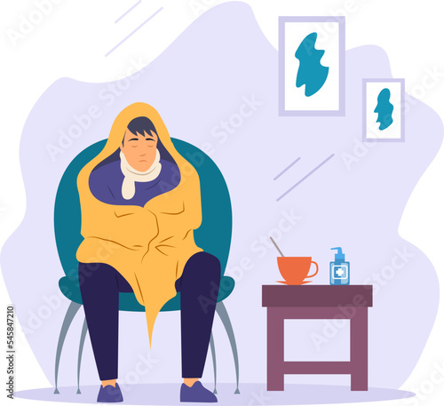 Man sitting in armchair wrapped in blanket. Teenage boy caught cold flu or virus, treatment of colds with hot herbal tea and spray