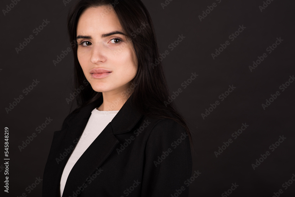 Portrait of an Armenian brunette girl in a black jacket on a black background. Portrait of an Armenian brunette girl in a black jacket on a black background.