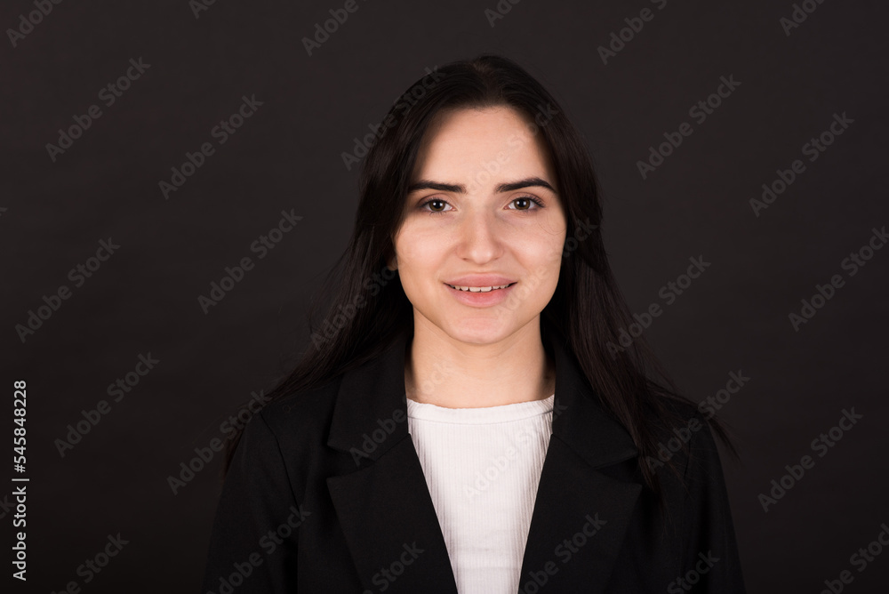 Portrait of a happy Armenian girl in a black jacket on a black background. Portrait of a happy Armenian girl in a black jacket on a black background.