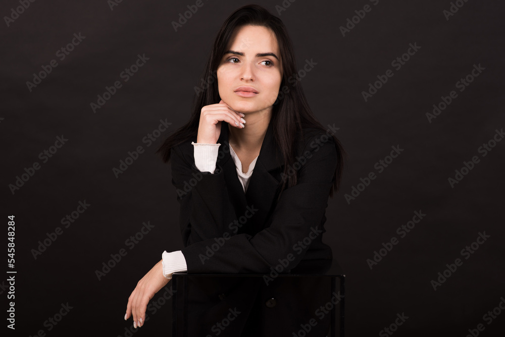 Portrait of an Armenian brunette girl in a black jacket on a black background. Portrait of an Armenian brunette girl in a black jacket on a black background.