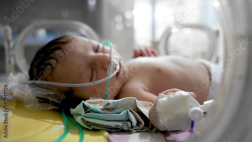 Closeup lovely little newborn baby infant lying in incubators for newborns, Newborn baby having the the breathing problem after birth, newborn in NICU, Neonatal intensive care unit