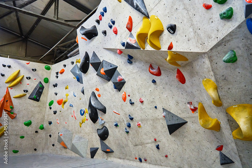 Wall for bouldering in gym with holds for climbing. Active extreme sport concept