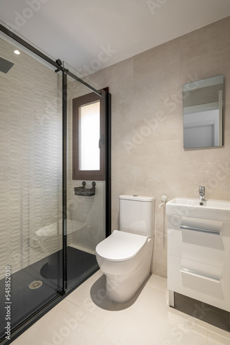 Modern empty bathroom with beige tiles  furniture and rectangular mirror