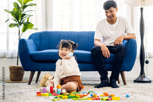 Portrait of enjoy happy love asian family father and little asian girl smiling activity learn and skill brain training play with toy build wooden blocks board education game at home