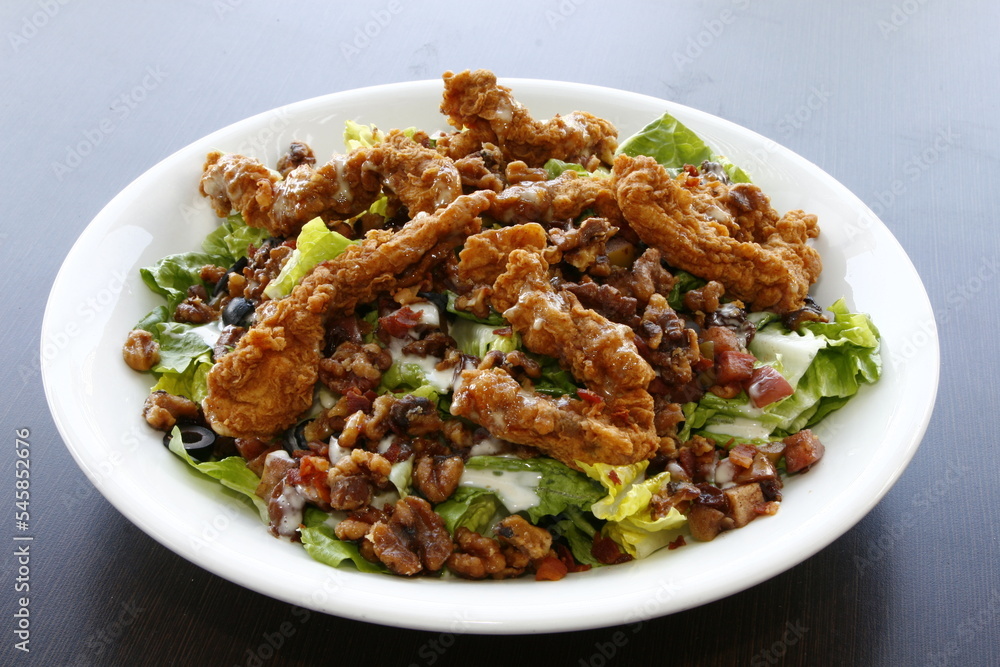 Crispy meaty chicken salad with olives and bacon bits