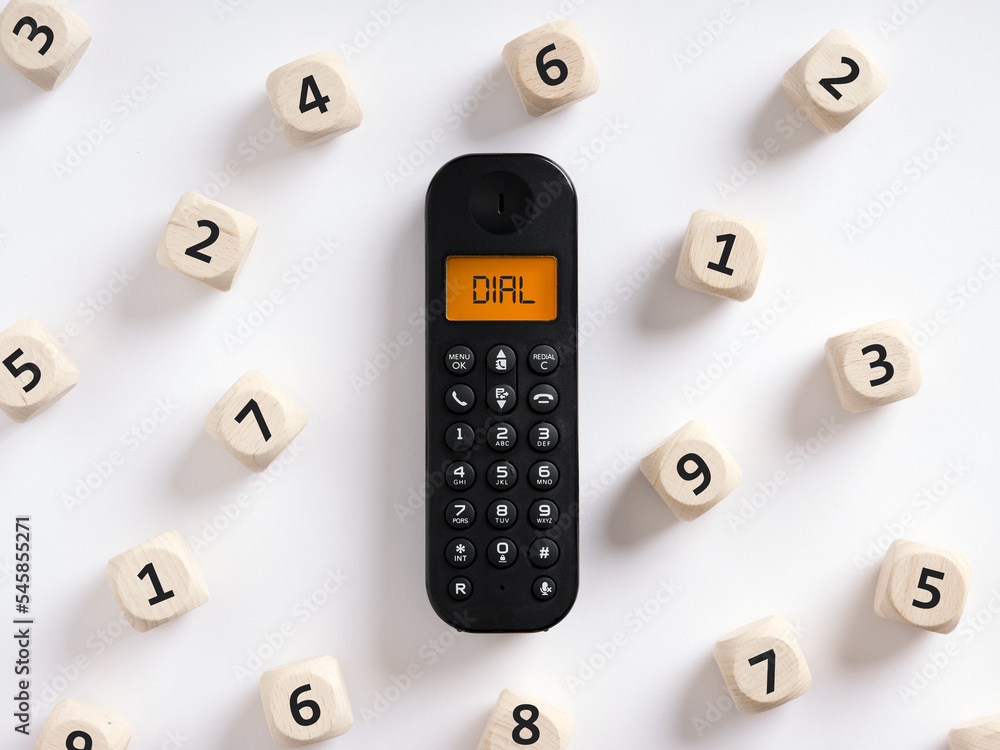 Retro wireless phone or telephone with the word dial on the screen with numbers around it. Dialing a phone number or call concept. Retro wireless phone or telephone with the word dial on the screen with numbers around it. Dialing a phone number or call concept.