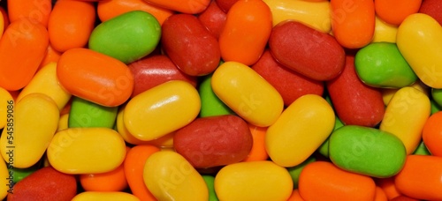 Colorful tic tac candy background in panorama banner format, vibrant multi color candies, macro full frame image.