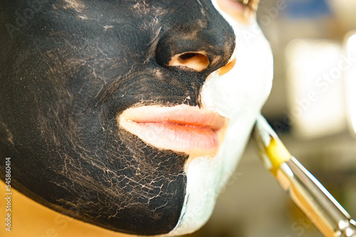 Girl black and green mud mask on face photo