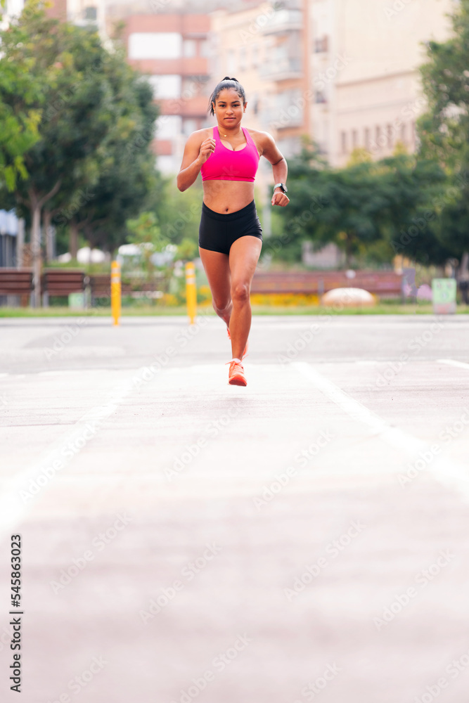 female athlete running on the city's athletics track during her training, urban sport and healthy lifestyle concept, copy space for text