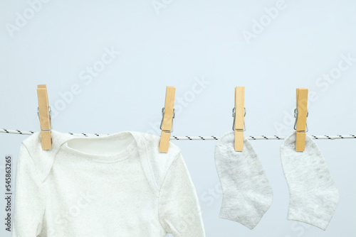 Child clothes hanging on twine against light background